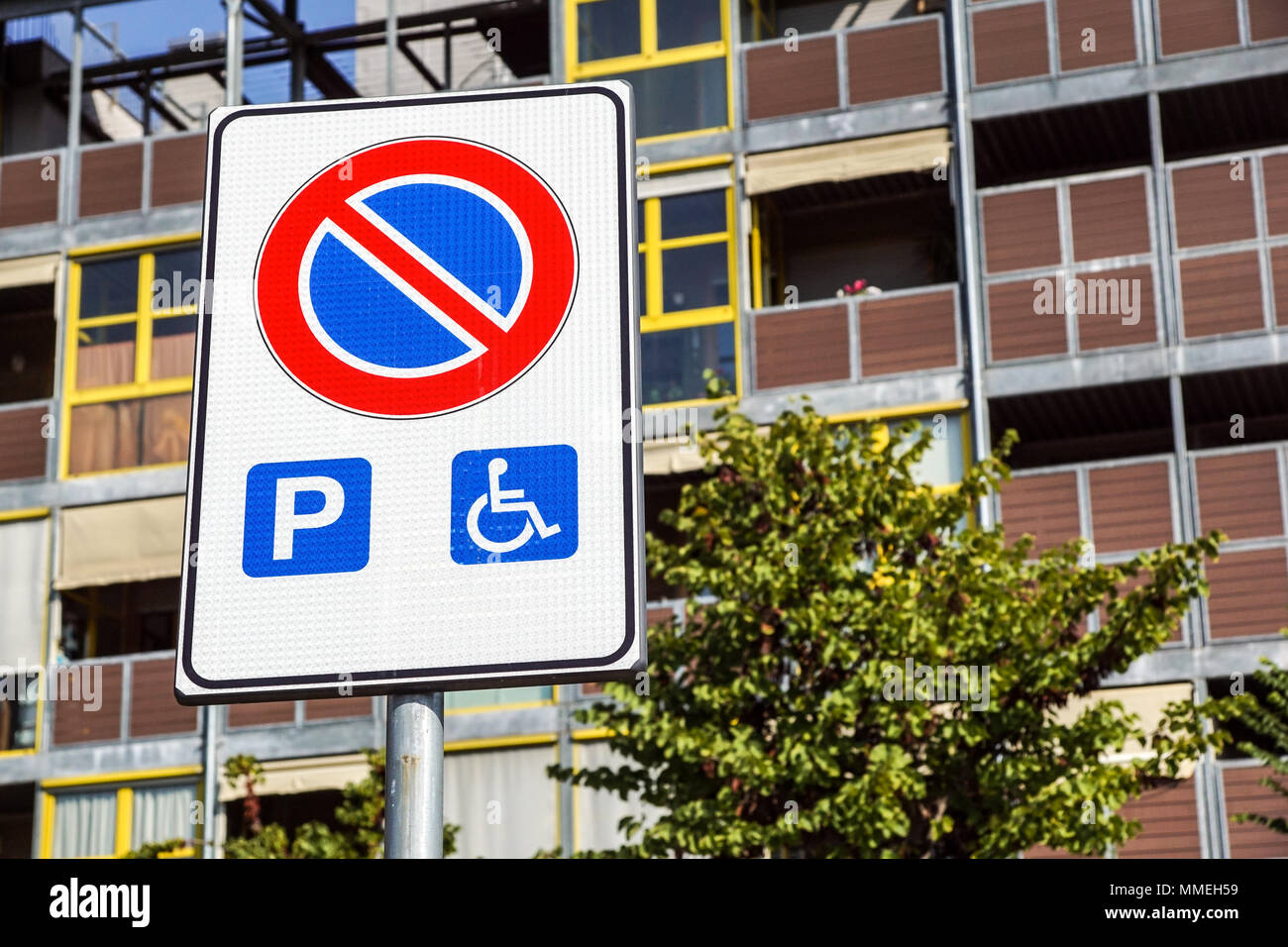 Parcheggio Disabili spazio e modo per sedie a rotelle e segno di simboli su un palo gli automobilisti di avvertimento Foto Stock
