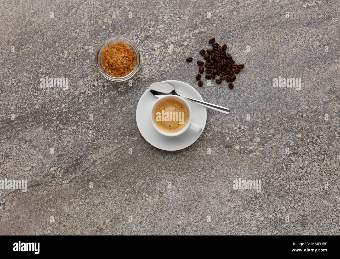 Un caffè espresso, girato su un piano di lavoro in pietra, con i chicchi di caffè. Foto Stock