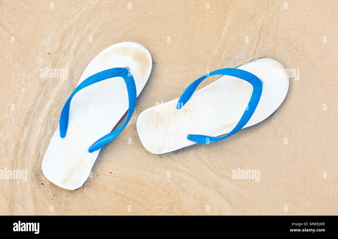 La vacanza estiva concetto . Il flip flop su una sabbiosa spiaggia dell'oceano Foto Stock