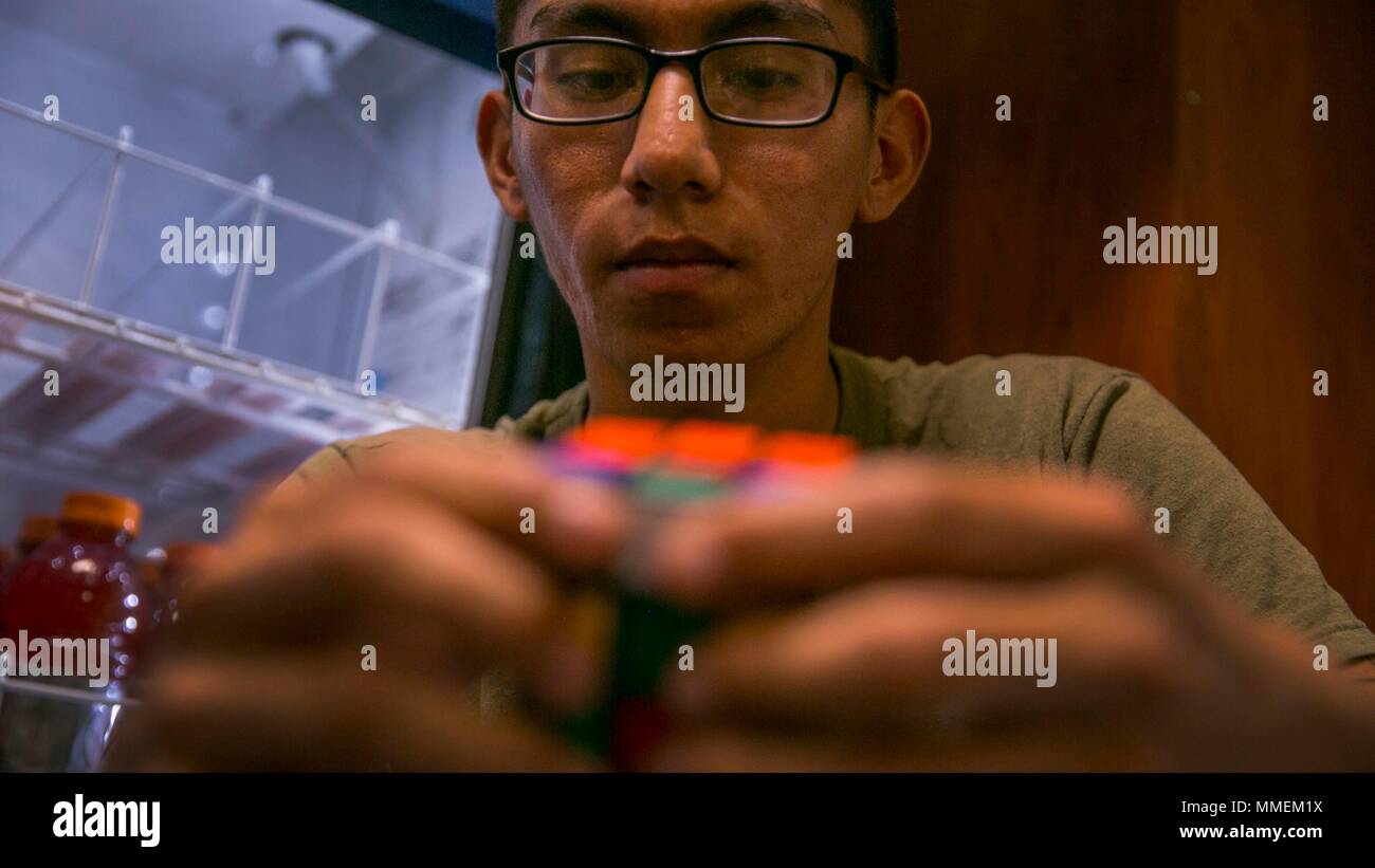 Stati Uniti Quinta Flotta Area di Responsabilità - Cpl. Kobe Loonsfoot, un atterraggio assistenza specialistica con il quindicesimo Marine Expeditionary Unit logistico dell elemento di combattimento, risolve un cubo di Rubik a bordo della USS Pearl Harbor (LSD 52) . Mentre distribuito Marines impiegano il loro tempo libero per favorire la nascita di nuove competenze e di hobby. Xv Marine Expeditionary Unit è intrapreso l'America anfibio gruppo pronto e viene distribuito per mantenere la sicurezza regionale negli Stati Uniti Quinta Flotta area di operazioni. (U.S. Marine Corps foto di Cpl. F. Cordoba) Foto Stock