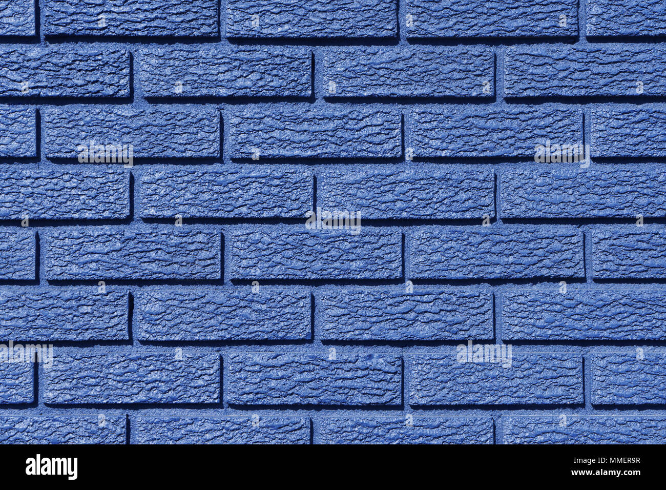 Primo piano della parte esterna di un muro di mattoni dipinto in blu. Foto Stock