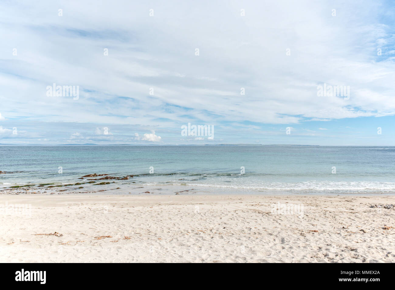 Sulla spiaggia di Baia Sannick, Caithness, Highlands, Scozia, guardando fuori verso le isole Orcadi che abbracciano l'orizzonte. Foto Stock