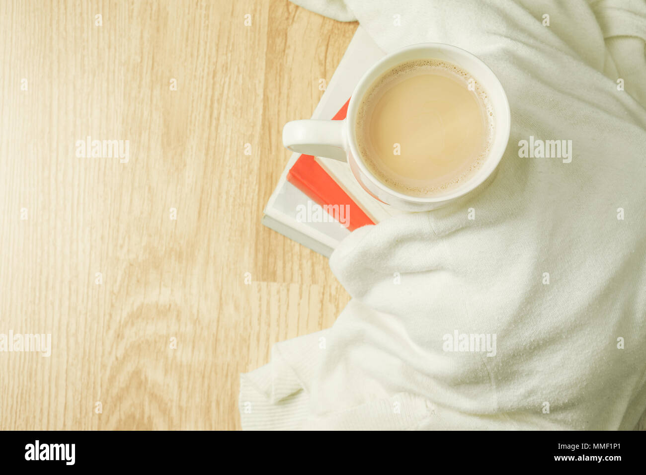 Tazza di caffè, panno bianco e la pila di libri sulla sommità di uno sfondo di legno. La colazione del mattino. Vista dall'alto. Foto Stock
