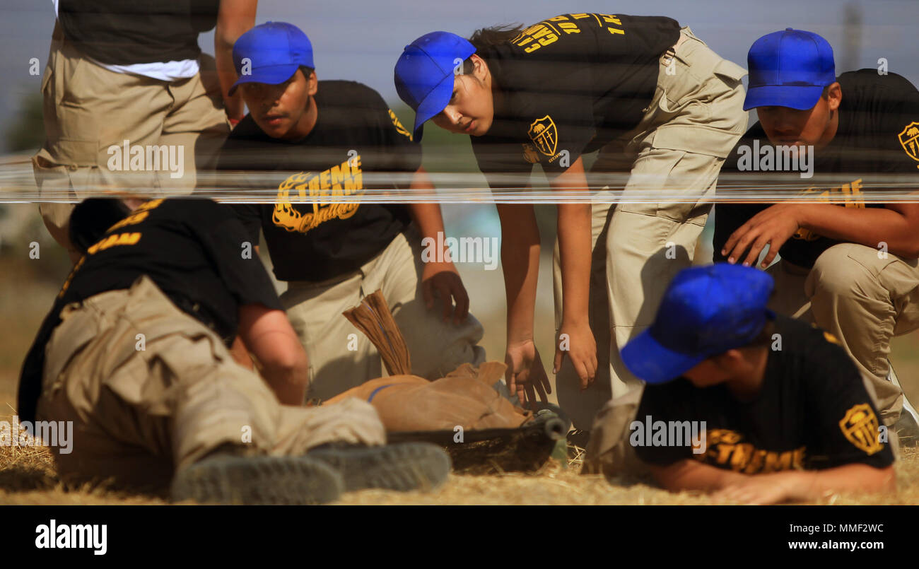 Un team della California Cadet Corps cadetti da Indian Springs High School di San Bernardino, California, e Porterville High School di Porterville, California, iniziano a bassa crawl mentre la manovra con una lettiera che trasportano sacchi di sabbia 28 ottobre 2017, durante la California Cadet Corps Xtreme Team Challenge tenutosi a forze congiunte Training Base Los Alamitos, California. Cadetti perseverato attraverso quattro aspetti della lettiera portano sfida tra cui il giogo della bilancia, ascendente e discendente di una torre, overhead di portare e la bassa-crawl . (Air National Guard foto di Senior Airman Crystal Housman) Foto Stock