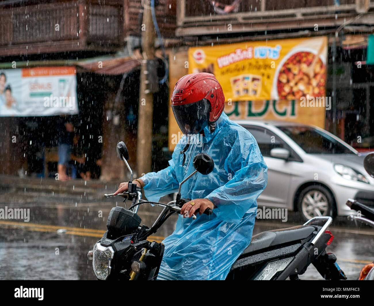 Pioggia. moto rider nella pioggia torrenziale. Thailandia stagione dei monsoni. Sud-est asiatico. Foto Stock