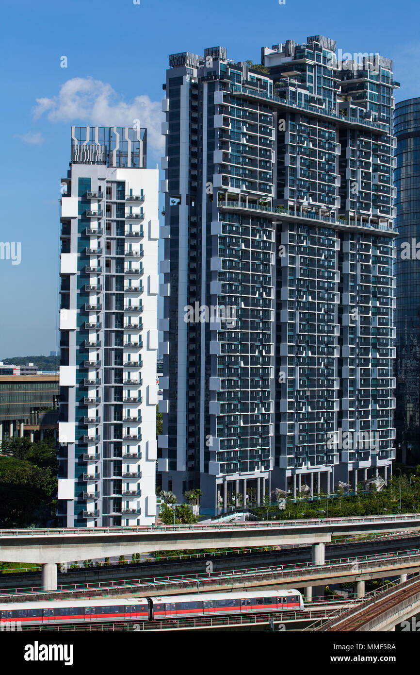 Vista verticale di un treno che viaggia di fronte al condominio J gateway a Jurong East. Singapore. Foto Stock