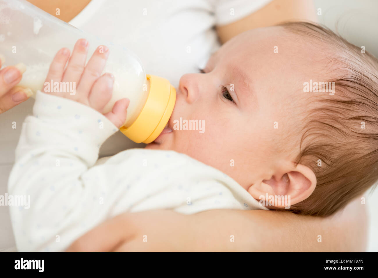 Closeup ritratto di adorabili baby boy succhiare il latte dal flacone Foto Stock