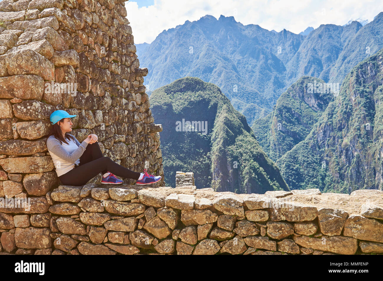 Donna sit in Machu Picchu rovina e guardando il bellissimo paesaggio Foto Stock