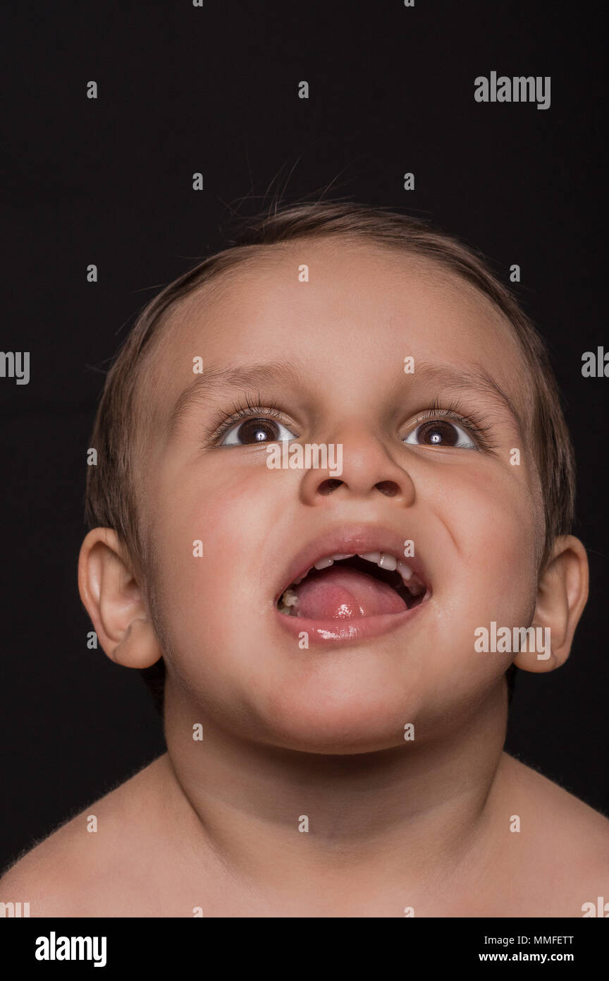 Chiusura del bellissimo ragazzino ritratto su sfondo scuro Foto Stock