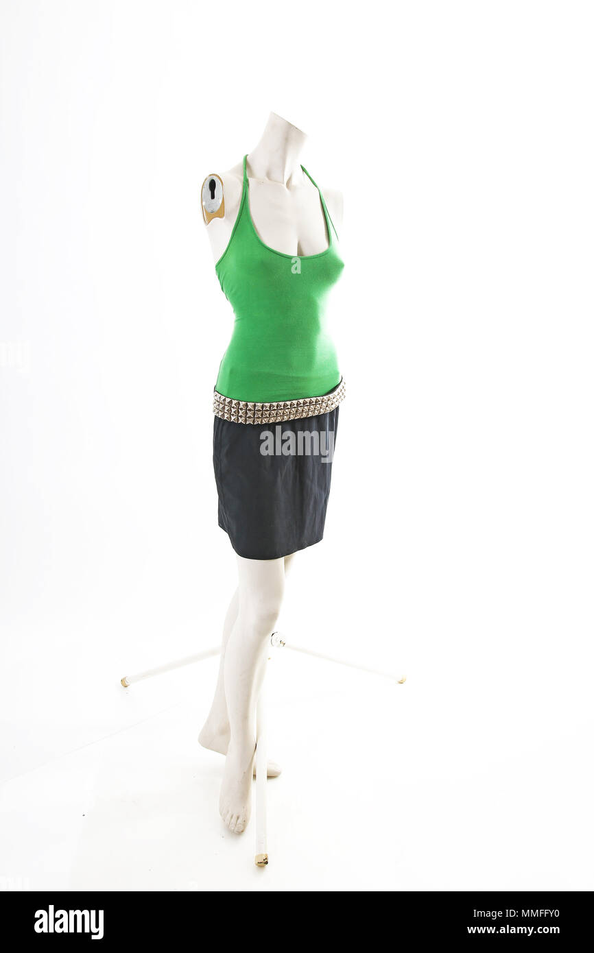 Verde in alto e gonna nera sul manichino full body shop display. Moda Donna stili, vestiti di bianco su sfondo per studio. Foto Stock