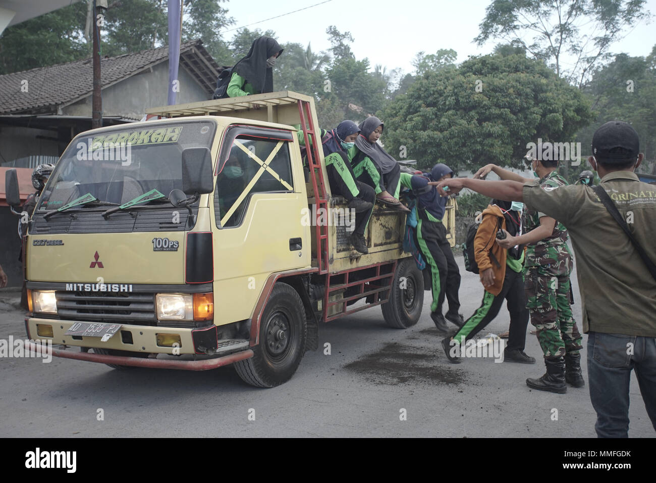 Sleman, Indonesia. 11 Maggio, 2018. Gli studenti evacuato dalla sabbia carrello per arrivare al punto di incontro durante il Merapi eruzione freatica. Yoga Galih Wicaksono/Alamy Live News Foto Stock