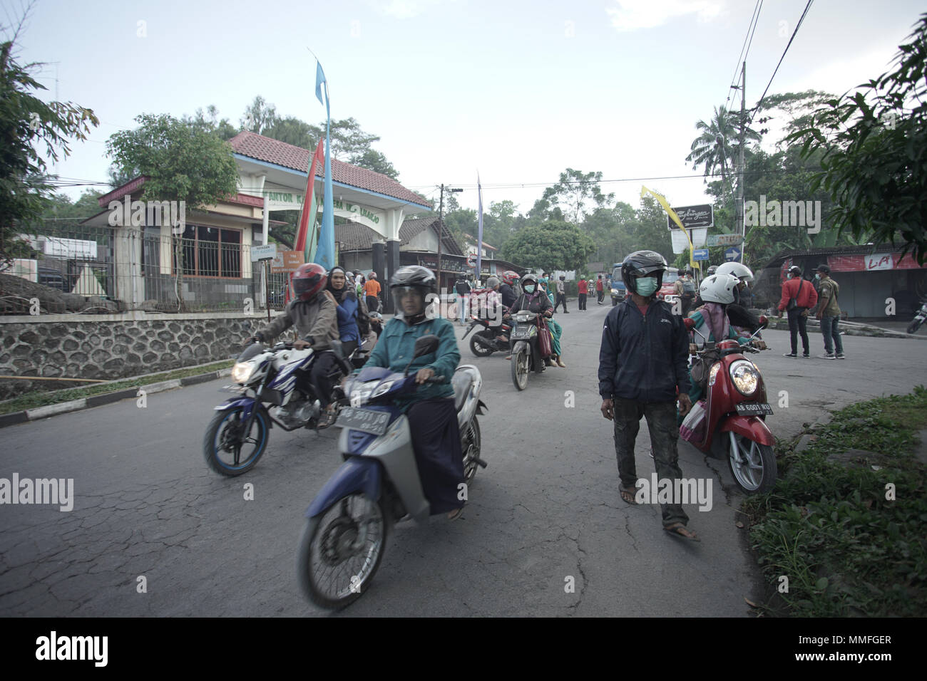 Sleman, Indonesia. 11 Maggio, 2018. La gente ride motociclo per raggiungere un luogo sicuro durante il Merapi eruzione freatica. Yoga Galih Wicaksono/Alamy Live News Foto Stock