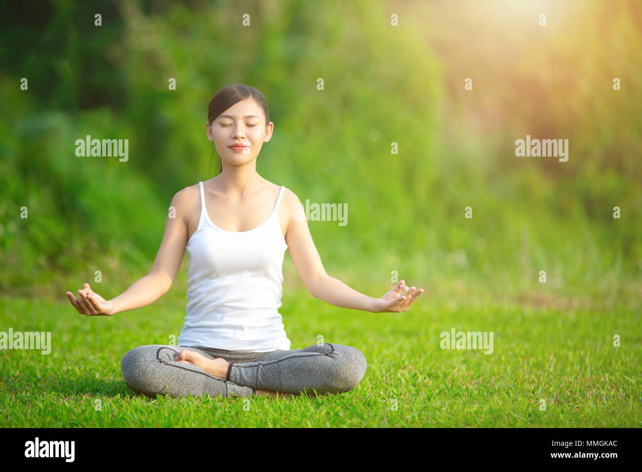 Signora la pratica dello yoga nel parco all'aperto, la meditazione. Foto Stock