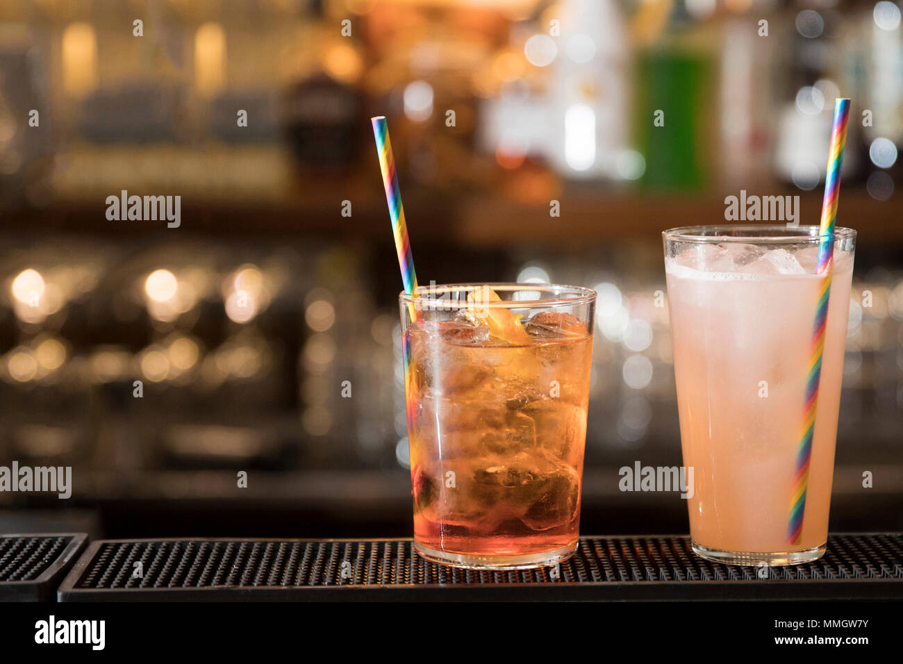 Primo piano di un banco di bar, due cocktail colorati ( spritz e pompelmo rosa cocktail) con una bella cannuccia. argomenti e concentrarsi sulla destra Foto Stock