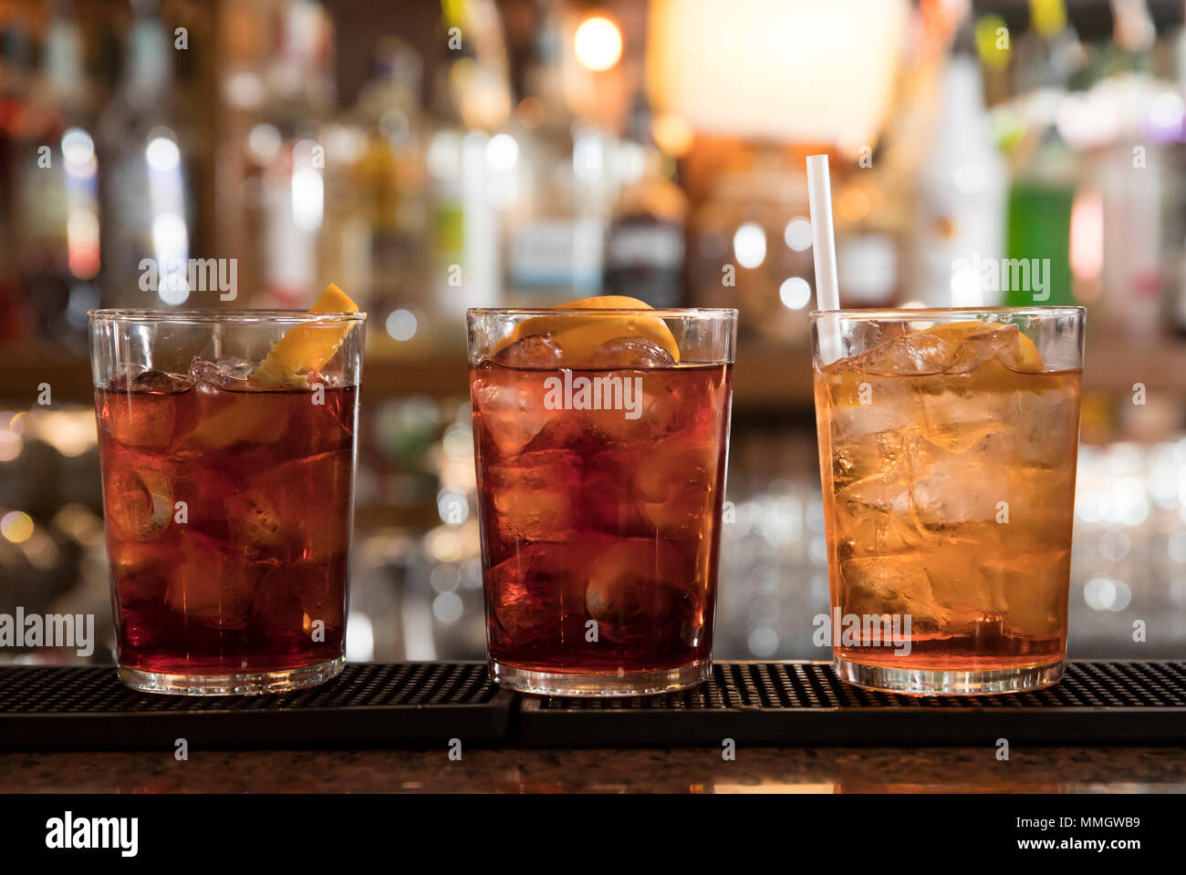 Primo piano di un banco di bar, tre cocktail rinfrescanti pronto a servire, spritz e cocktail americano Foto Stock