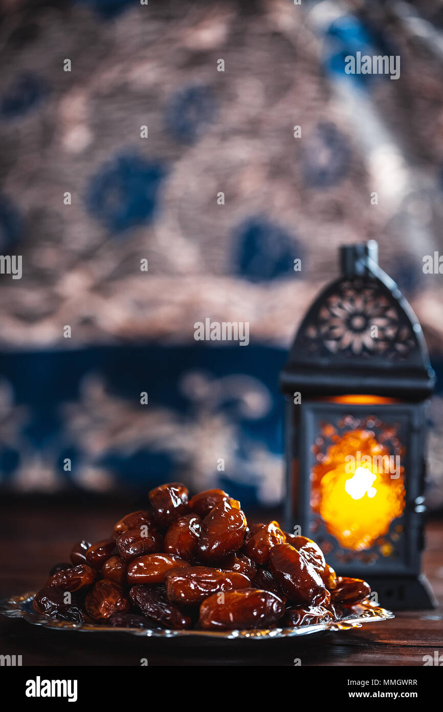 La festa islamica del mese sacro del Ramadan Kareem. Bellissimo sfondo con un brillante lanterna Fanus e datteri secchi su tavole di legno. Spazio libero f Foto Stock