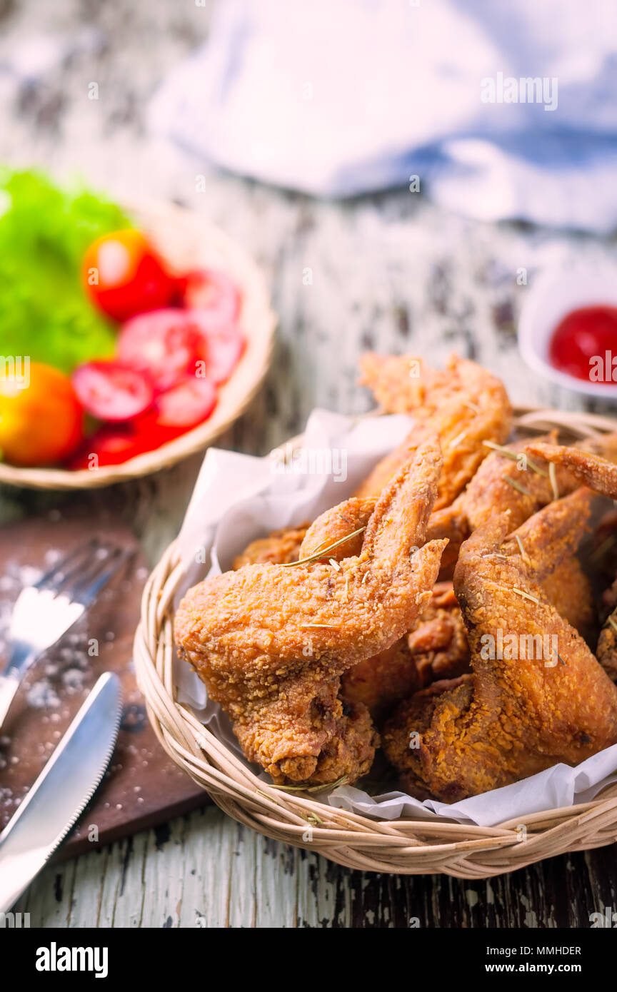 Fritti di ali di pollo e ketchup su sfondo di legno Foto Stock