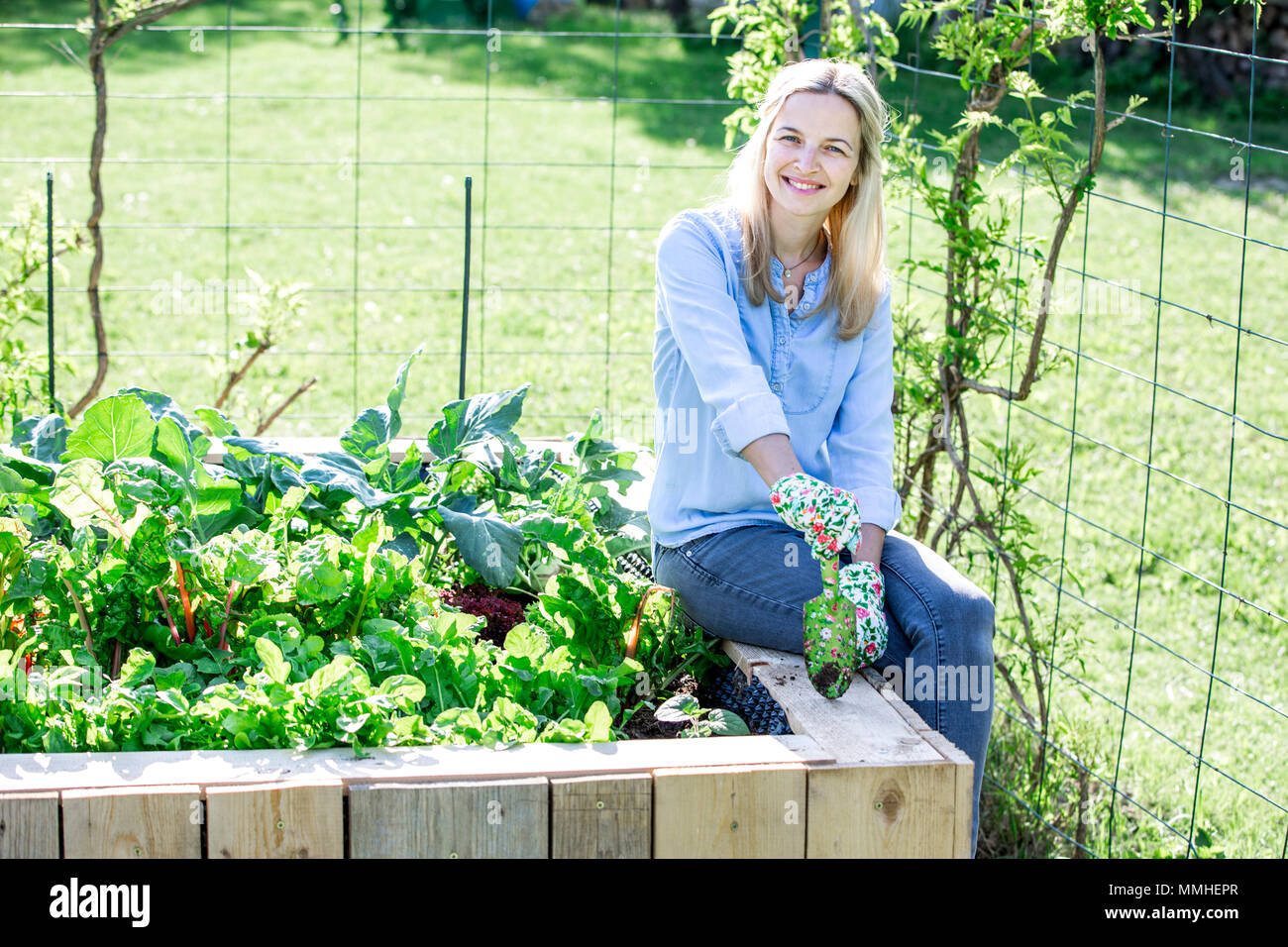 Giardinaggio - donna felice è orgogliosa del proprio letto sollevata Foto Stock