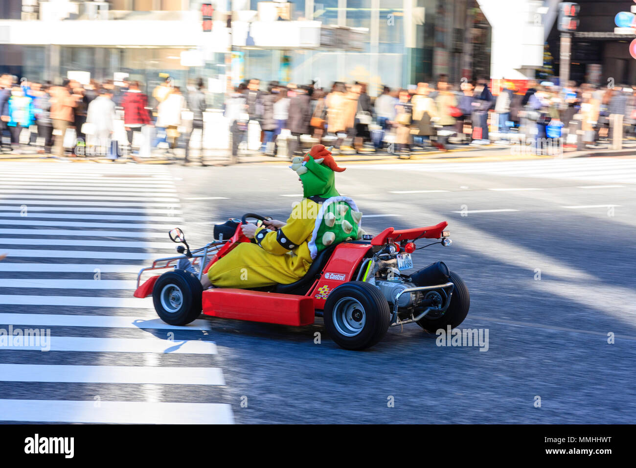 Tokyo, Shibuya crossing. Popolari attività turistiche, guida MariCar, Mario Kart mentre vestita come Mario carattere. Sfondo sfocato. Foto Stock