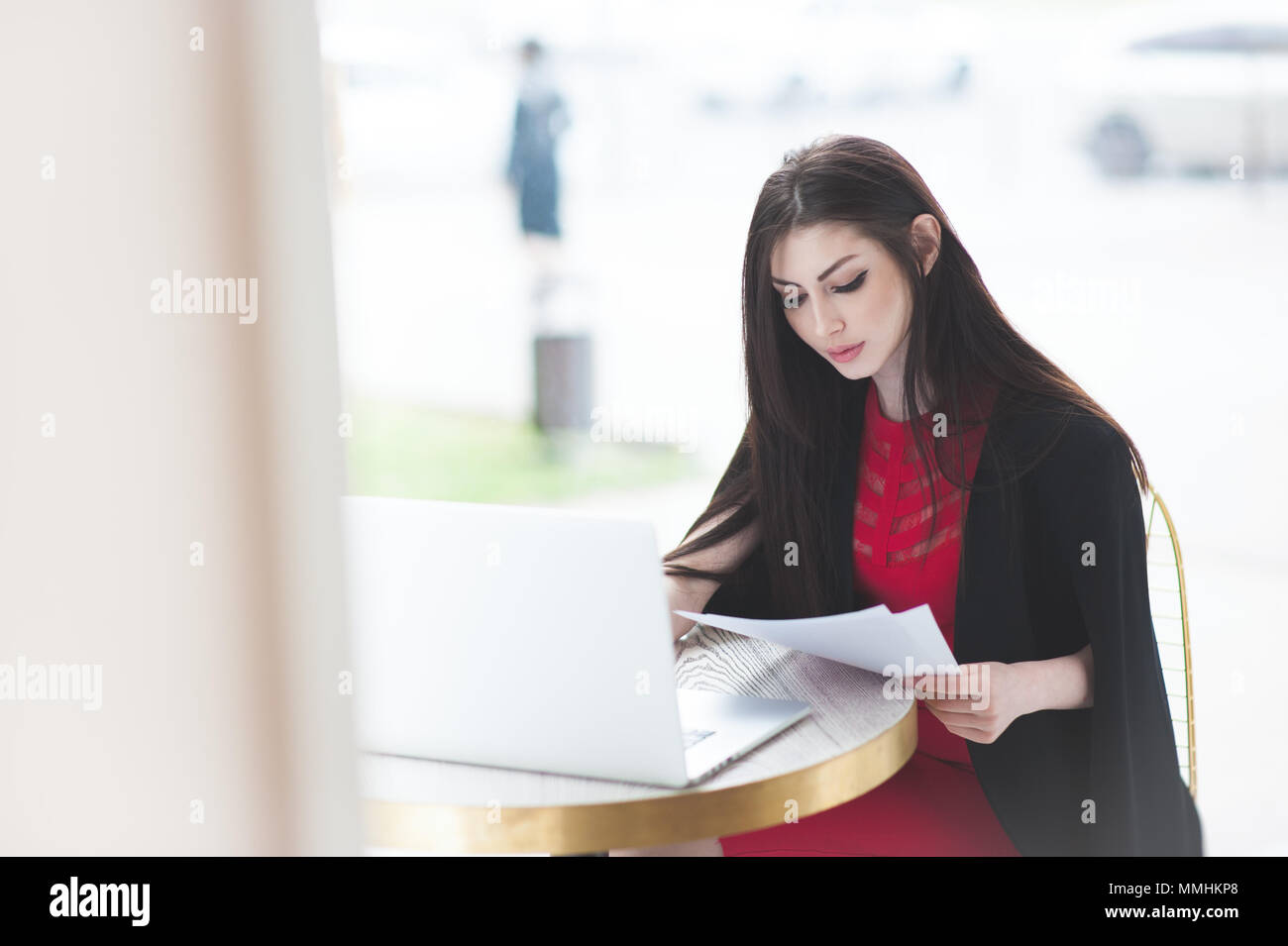 Smart Business ragazza seduta nel cafe e studiano documenti udienza dal computer portatile Foto Stock