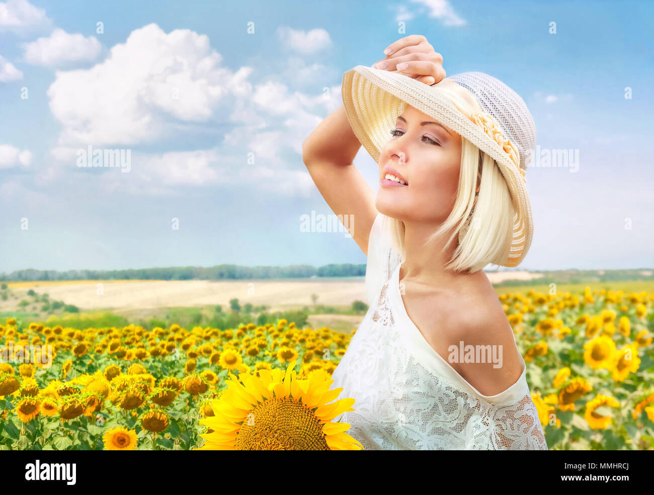 Ritratto di bella donna romantica in estate hat a fioritura campo di girasoli Foto Stock