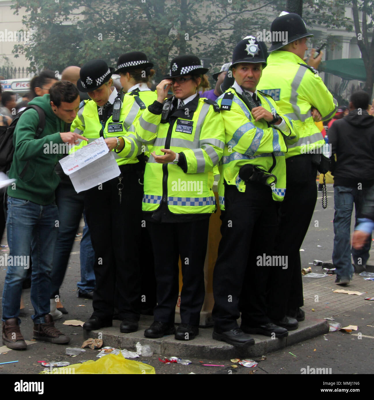 Un mazzetto di rami in piedi su un semaforo con un isola durante il carnevale di Notting Hill. La polizia attaccano insieme nel caos Foto Stock