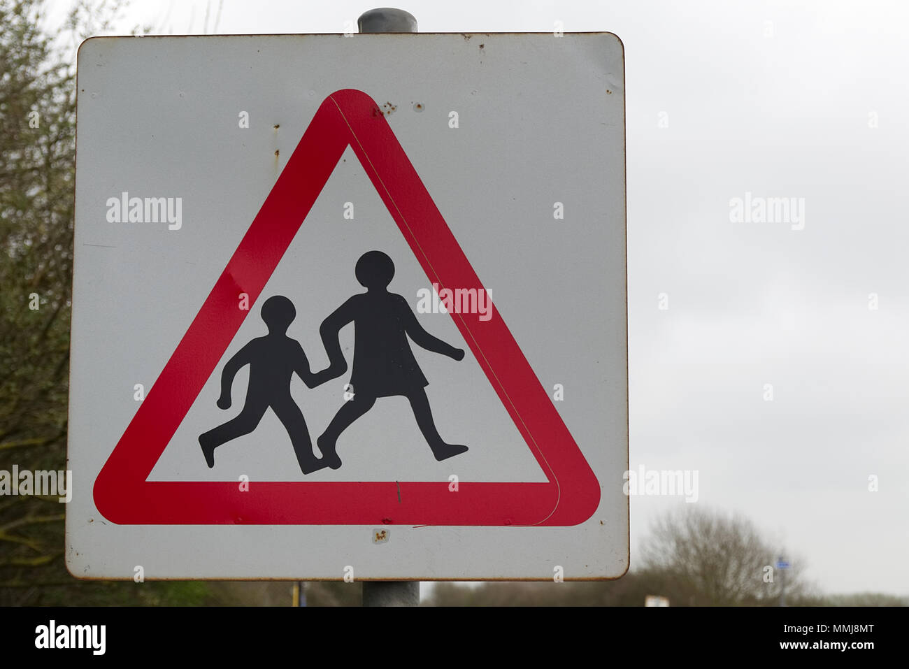 Vecchio, weathered, rosso e bianco strada triangolare simbolo di sicurezza bambini di attraversamento scuola pedoni in modo sicuro Foto Stock