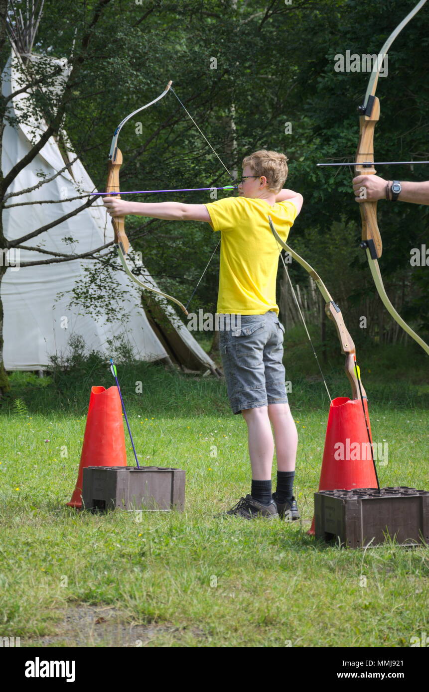 Un ragazzo in un campo di tiro con l'arco a un campo estivo in Irlanda Foto Stock