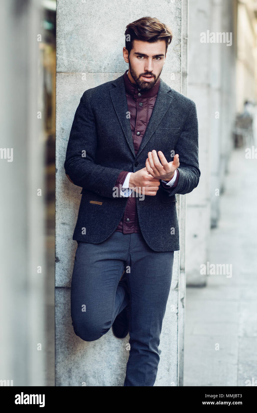 Giovane uomo barbuto, modello di moda, in background urbano indossando  british elegante abito. Ragazzo con la barba e acconciatura moderna in  strada Foto stock - Alamy