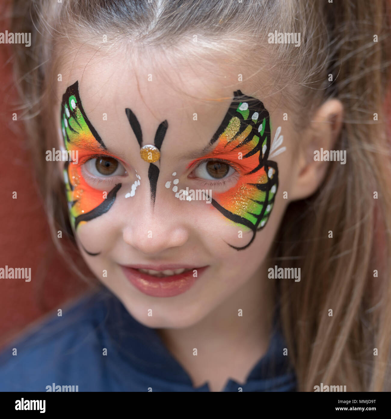 Close up della ragazza con farfalla dipinto sul volto Foto Stock