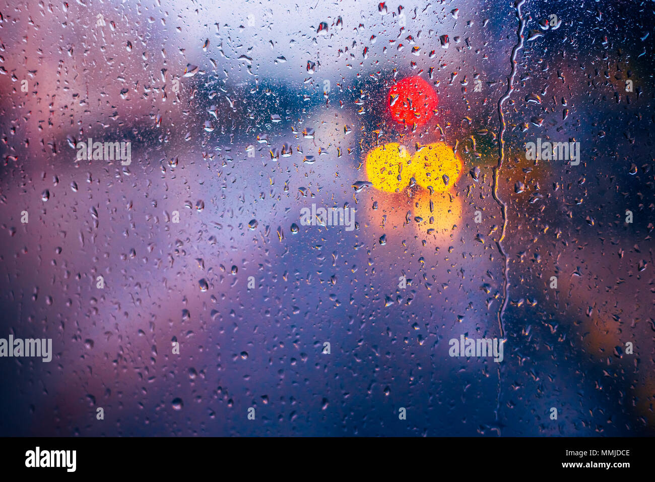 Gocce di pioggia sul vetro azzurro sfondo. Street Bokeh Lights Out di messa a fuoco. Autunno sfondo astratto Foto Stock