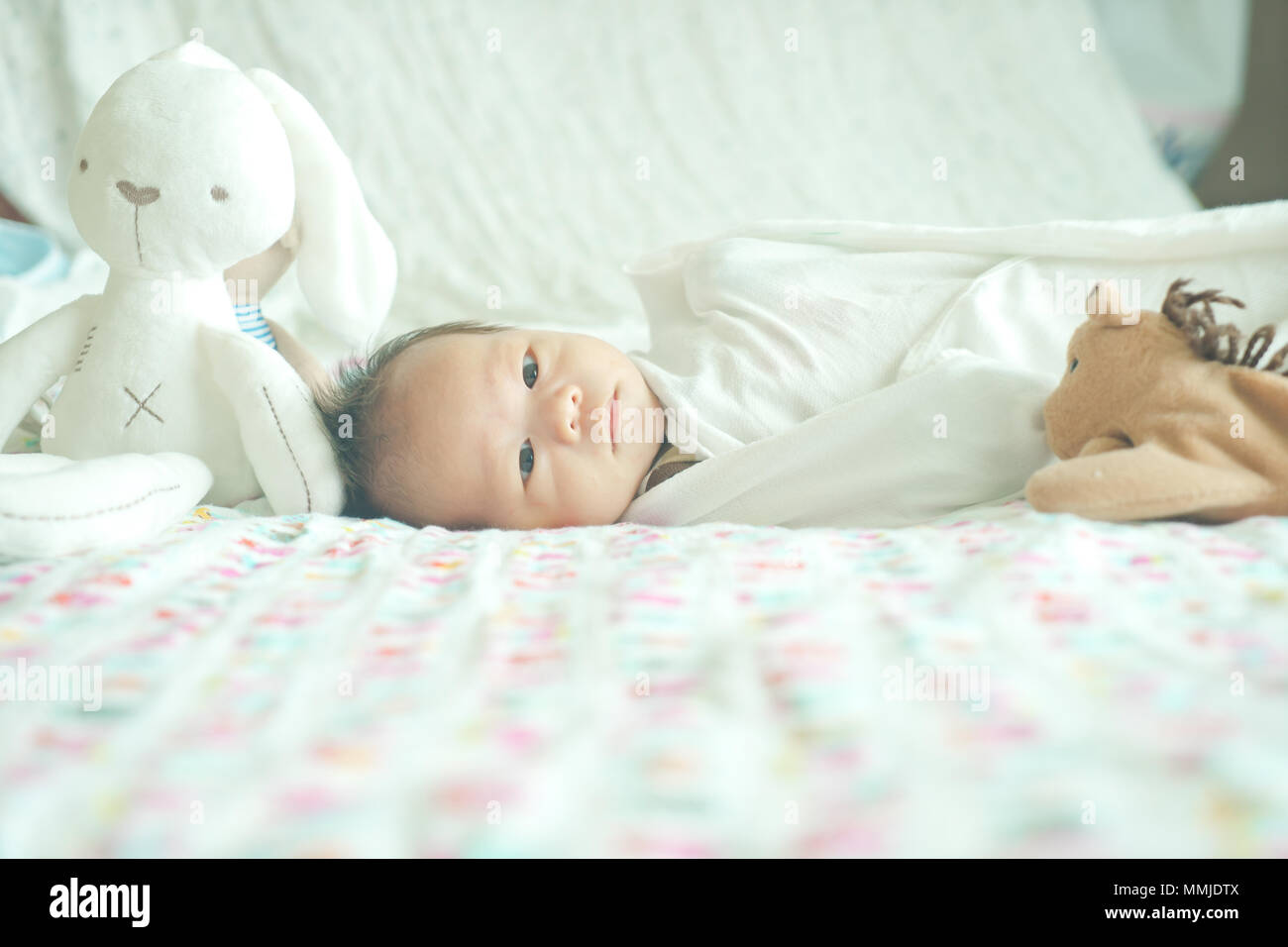 Carino adorabile neonato bimbo avvolto o swaddle in una coperta, dormire e  talvolta entrambi gli occhi aperti in letto per bambini Foto stock - Alamy