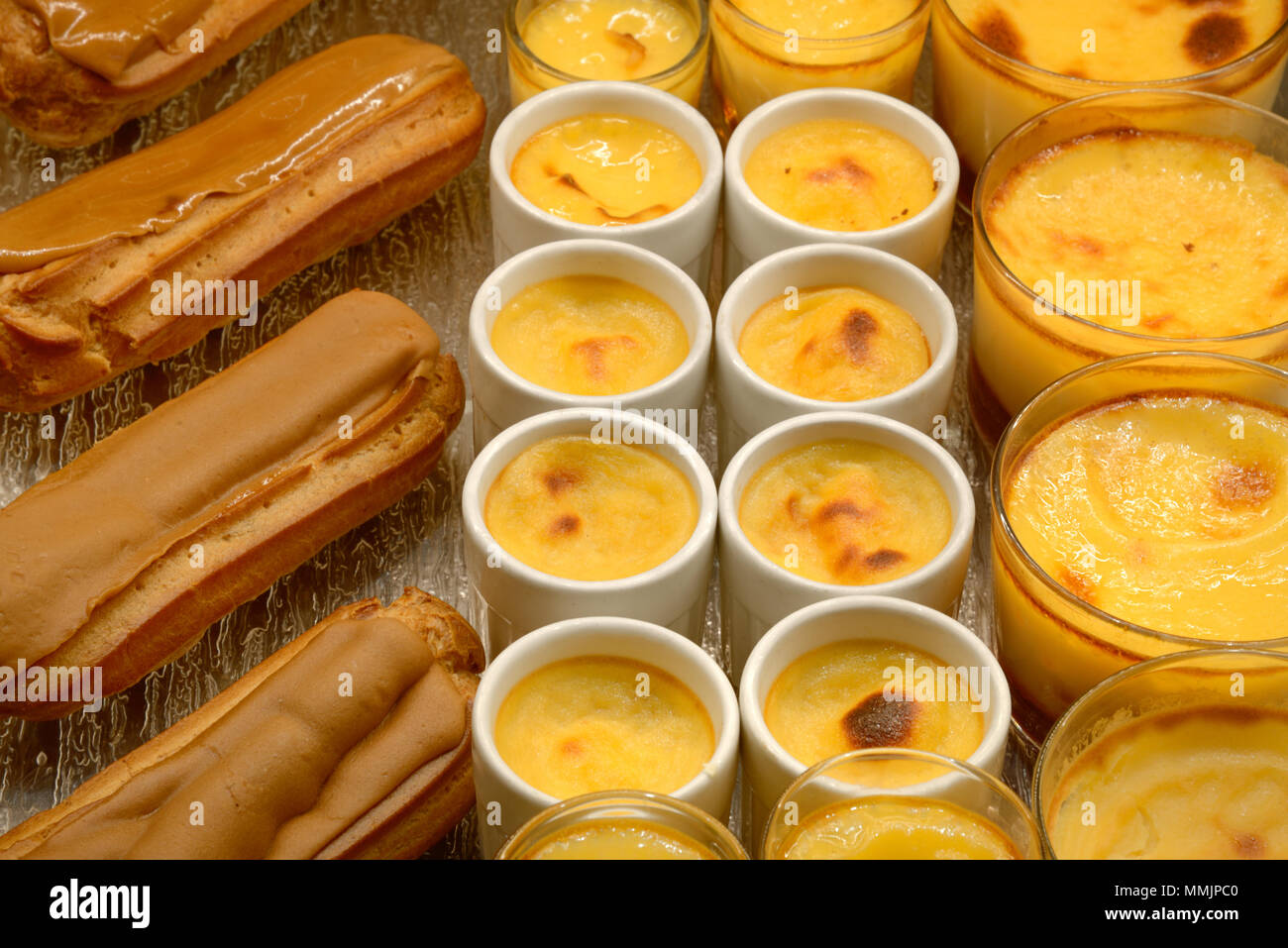 Visualizzazione delle creme caramelle & Coffee Eclairs dolci o torte in una pasticceria francese in Francia Foto Stock