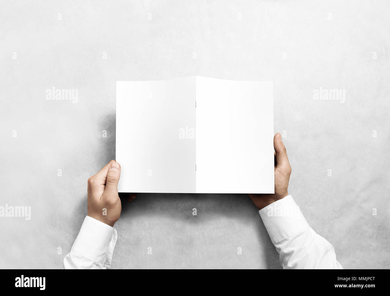 Mano azienda vuoto brochure bianco mockup, vista dal lato posteriore. Opuscolo di presentazione del coperchio. Foto Stock