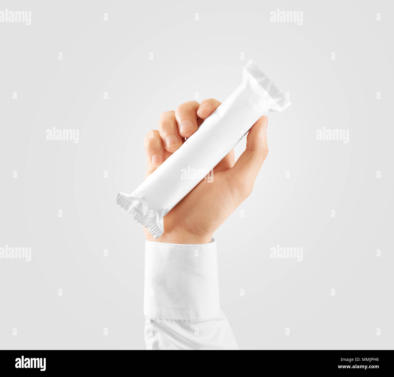 Schermata bianca vuota candy bar plastica avvolgere mockup tenere in mano, percorso di clipping. Vuoto barra di cioccolato modello di imballaggio. Choco factory logo pacchetto candybar mock up. Dolce pasticceria energy bar cover Foto Stock