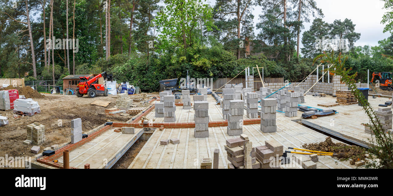 Blocchi di brezza impilati sul pavimento di una nuova casa in costruzione in una zona residenziale giardino suburbano infill building site, Surrey, Inghilterra del sud-est Foto Stock