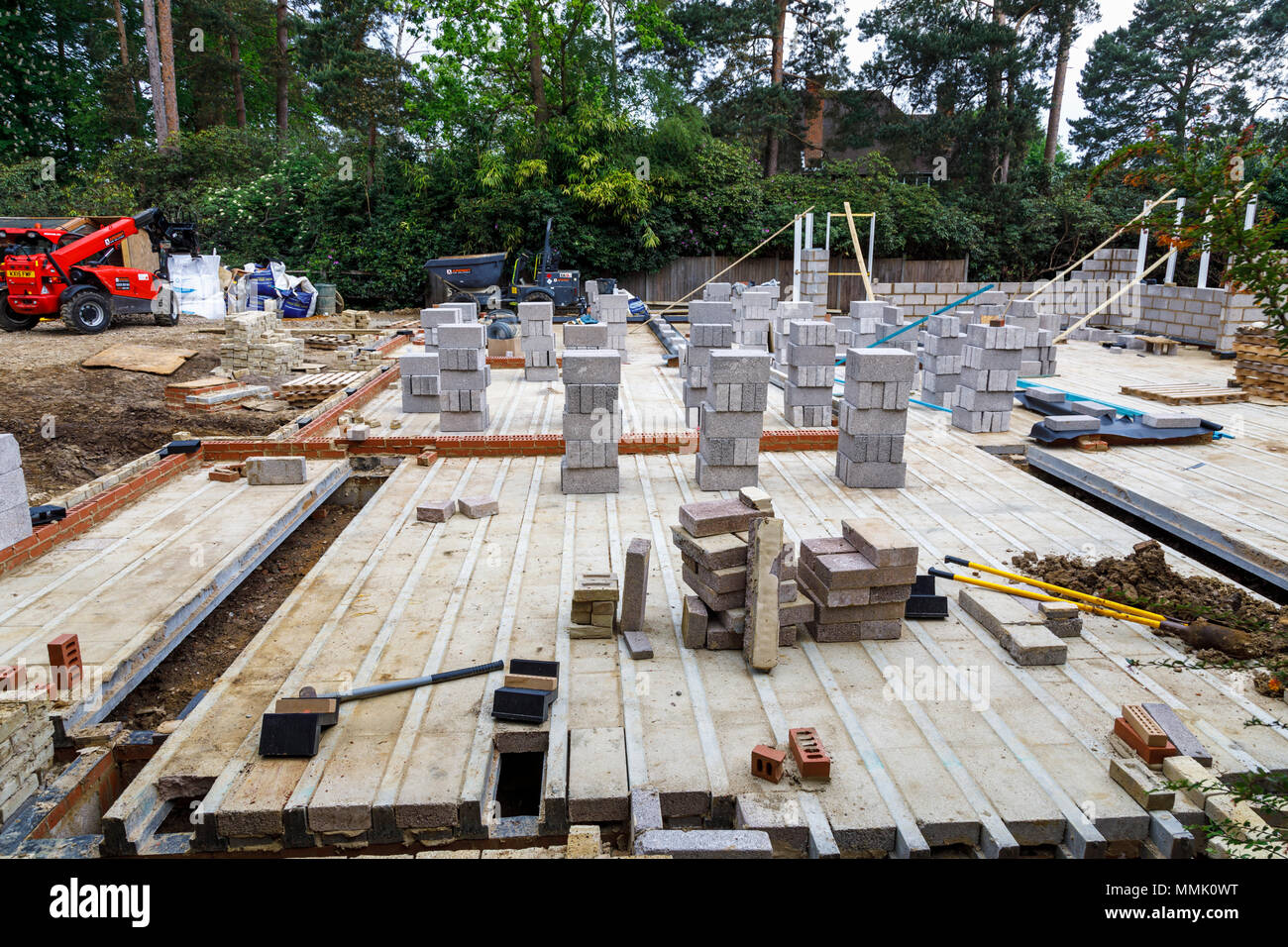 Blocchi di brezza impilati sul pavimento di una nuova casa in costruzione in una zona residenziale giardino suburbano infill building site, Surrey, Inghilterra del sud-est Foto Stock