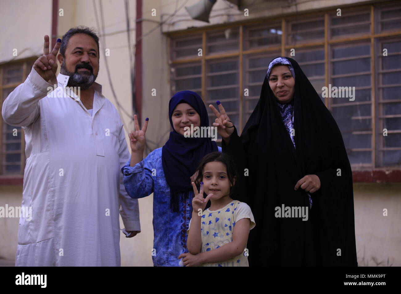 Baghdad in Iraq. Il 12 maggio 2018. Popolo iracheno flash segni di vittoria con le dita inchiostrato dopo la colata loro schede elettorali nelle elezioni parlamentari in corrispondenza di una stazione di polling a Baghdad, Iraq, 12 maggio 2018. Quasi 7.000 candidati sono in lizza per i posti a sedere in 329-Parlamento forte, che saranno in seguito eleggere Iraq·s presidente e primo ministro. Credito: Ameer Al Mohammedaw/dpa/Alamy Live News Foto Stock