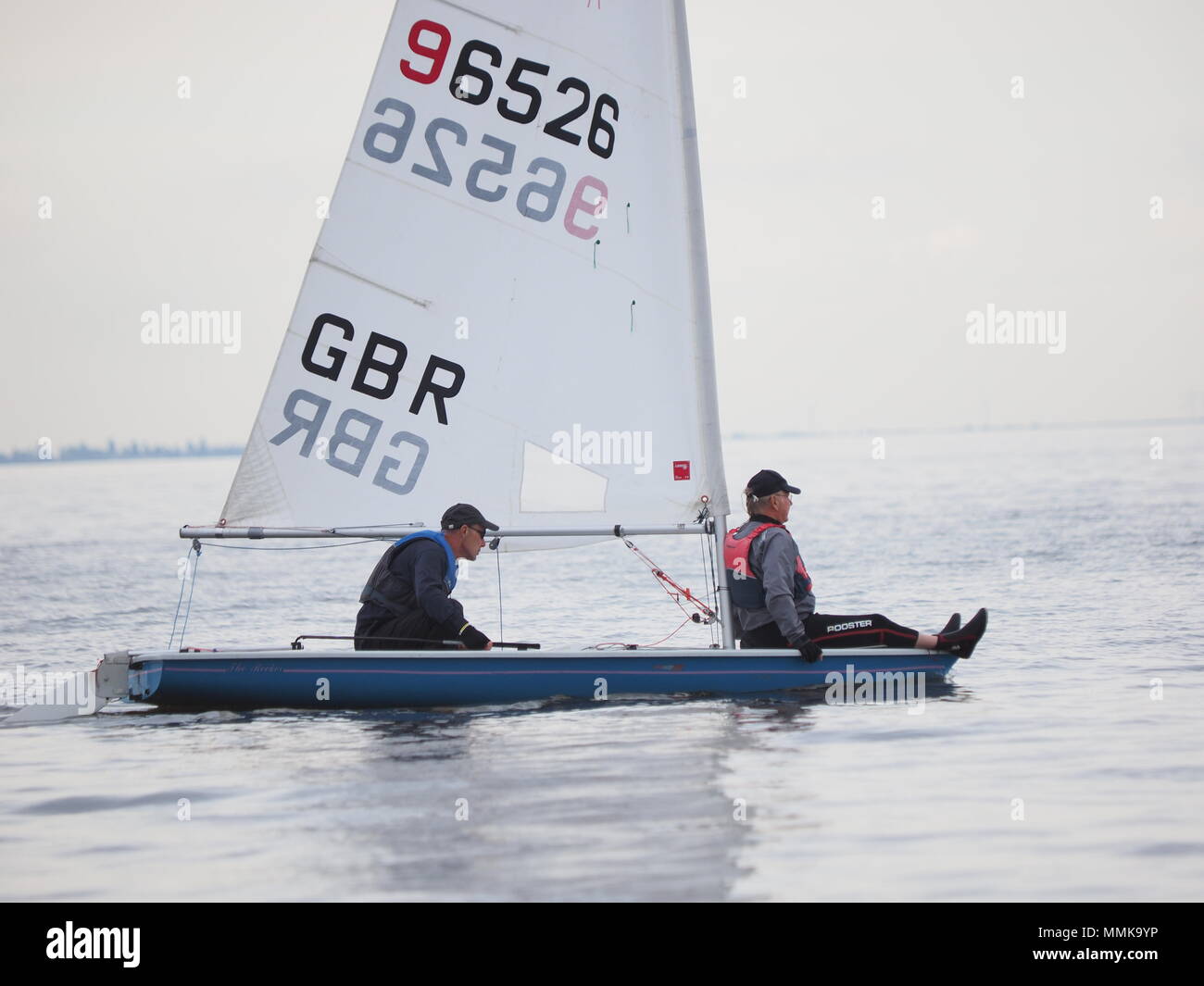 Sheerness, Kent, Regno Unito. Il 12 maggio 2018. Regno Unito Meteo: dopo un inizio brillante con venti leggeri, cloud e una leggera pioggia ha rotolato in per la Giornata aperta al Isle of Sheppey Sailing Club a Sheerness, Kent. Giornata delle porte aperte è parte del Royal Yachting dell Associazione Nazionale "spingere la barca all' iniziativa che vede il club di vela attraverso il Regno Unito tenere giornate aperte per introdurre i nuovi arrivati per lo sport della vela in maggio. Pic: un uomo prende un giro sulla prua di un laser di classe dinghy a vela. Credito: James Bell/Alamy Live News Foto Stock