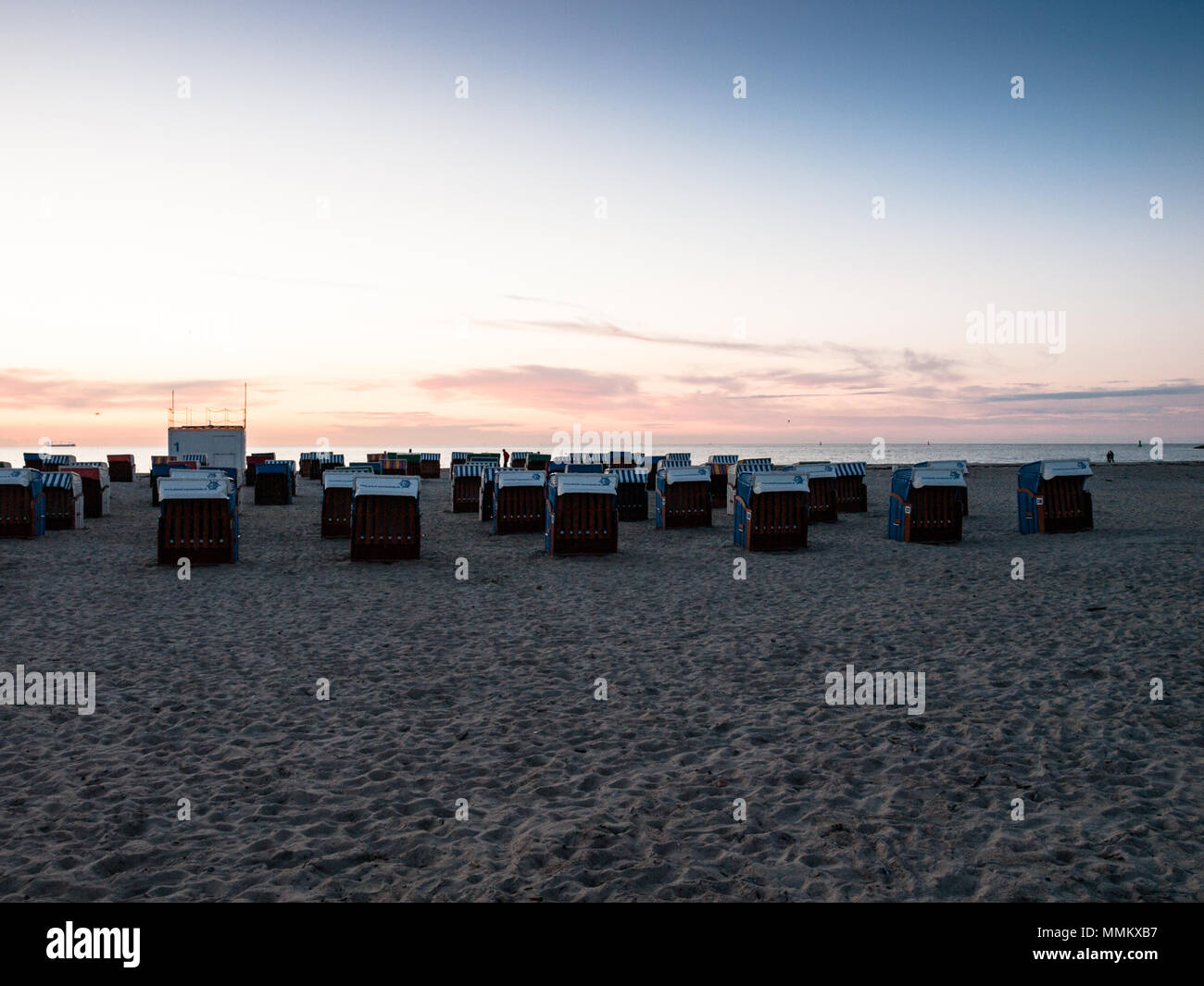 Chiuso sedie da spiaggia in vimini vuota sulla spiaggia sabbiosa a Mar Baltico, calma prima il lettore RUSH Foto Stock