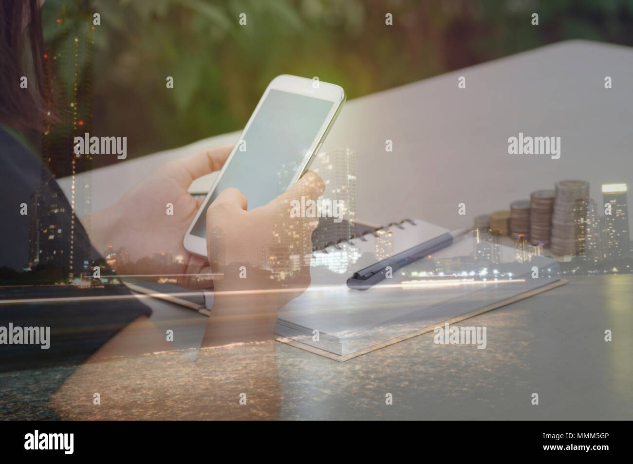 La doppia esposizione donne utilizzare il telefono sulla scrivania e la città di notte, concetto di comunicare e di contatto in finace, account e business Foto Stock