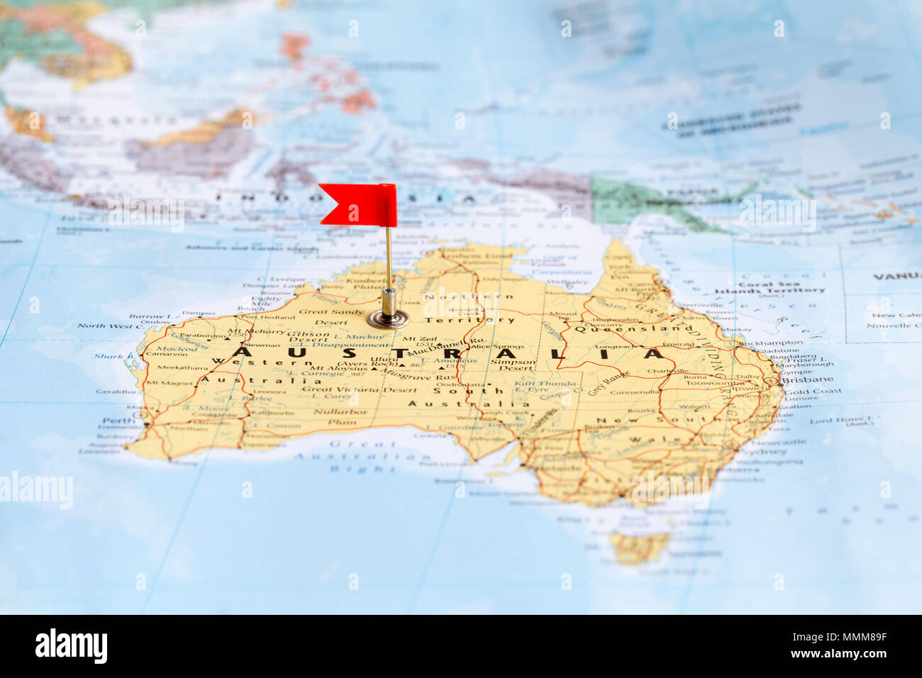 Piccola bandiera rossa marcatura Australia su una mappa del mondo. Foto Stock