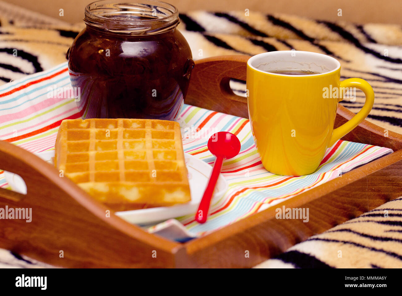 La prima colazione a letto su un vassoio - cialde, tè, marmellata Foto Stock