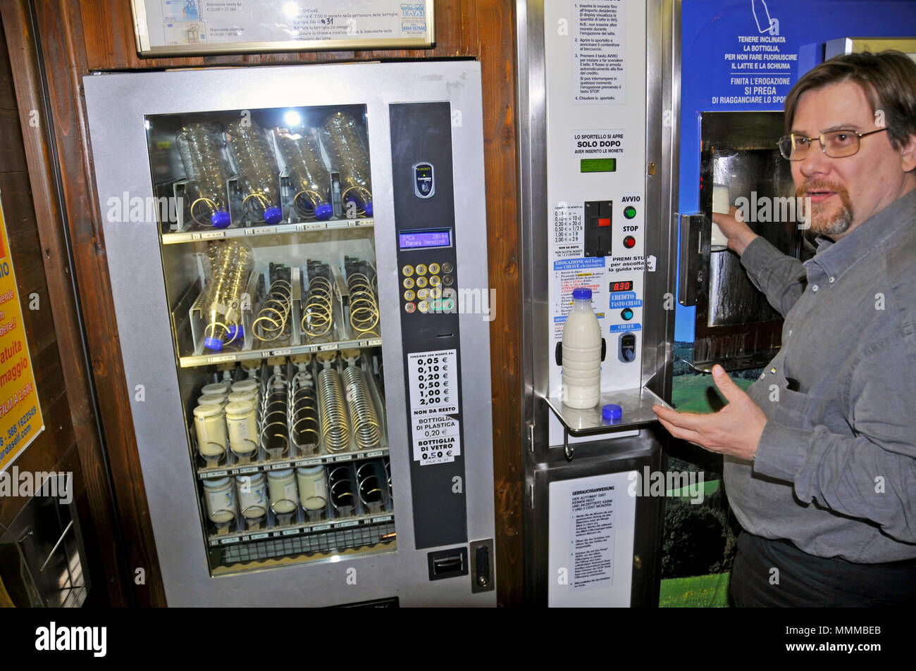 L'uomo utilizza un distributore automatico per il latte fresco, Riva del Garda, Trento, Italia Foto Stock