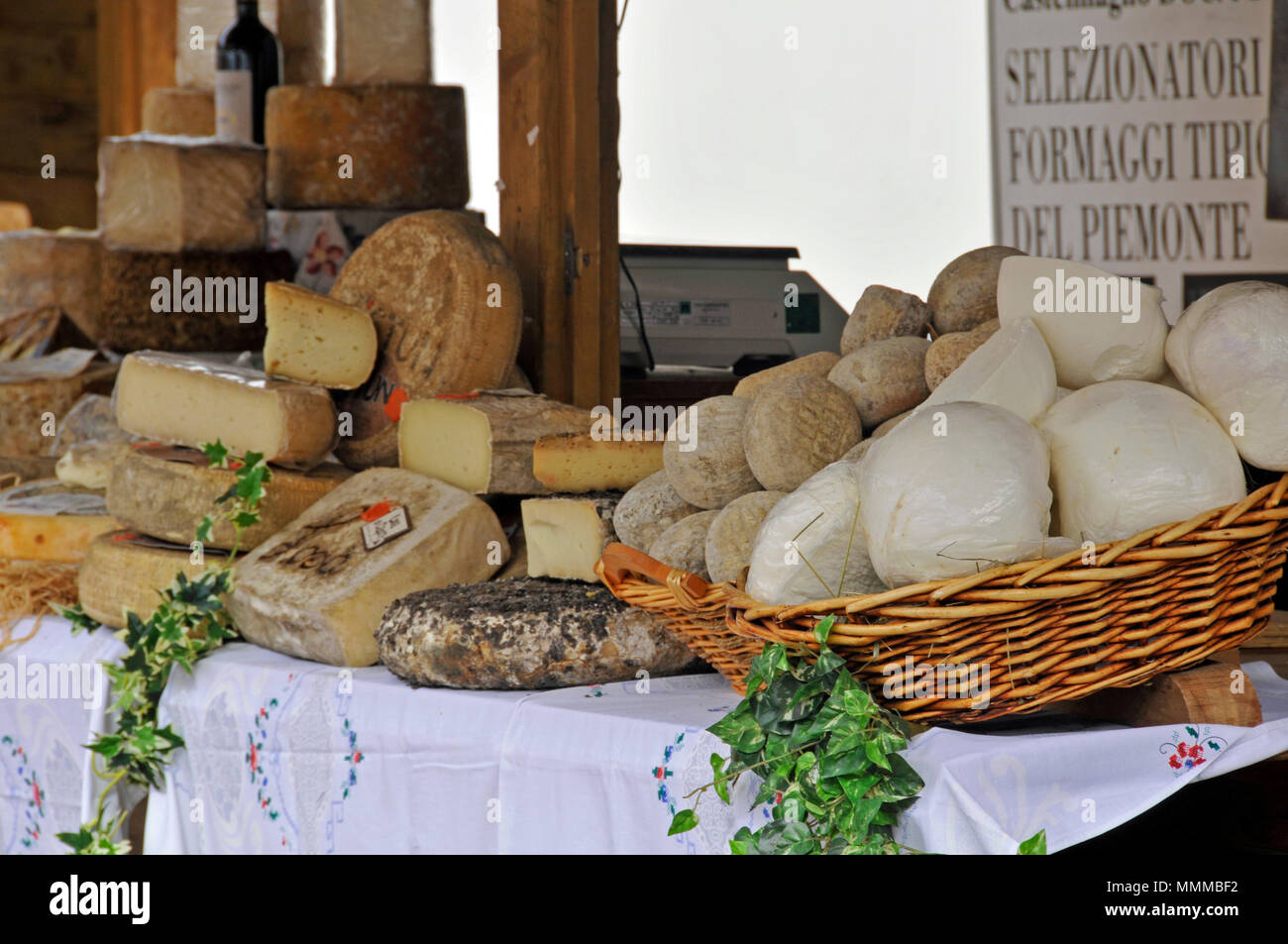 Vari tipi di prodotti localmente e formaggio sul display in un mercato aperto a Trento, Italia Foto Stock