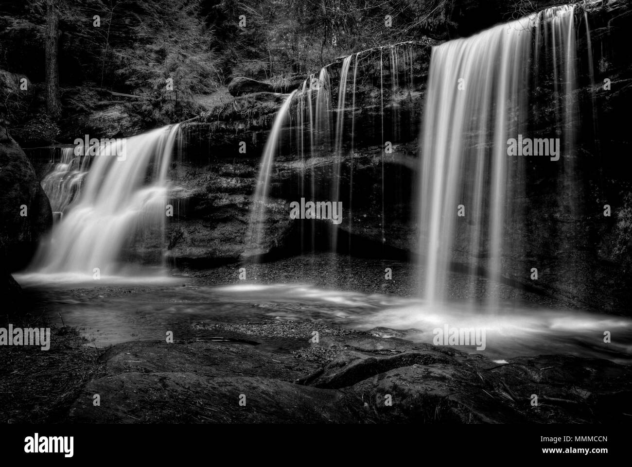 Una cascata di nascosto in Hocking Hills Ohio in bianco e nero. Che si trova nei pressi del famoso Cedar Falls dietro un grande blocco di crollo. Foto Stock