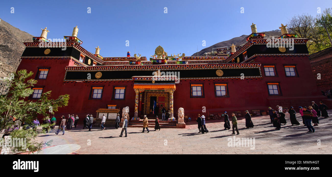 Il Tibetano pellegrini a piedi kora cerchi intorno al santo Bakong scrittura Stampa Monastero a Dege, Sichuan, in Cina Foto Stock