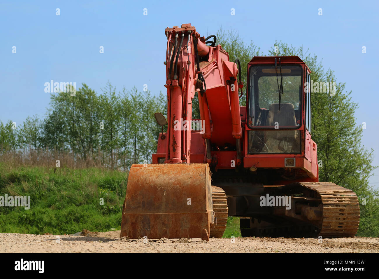 Vecchio arrugginito escavatore con finestra rotta sul terreno sabbioso Foto Stock