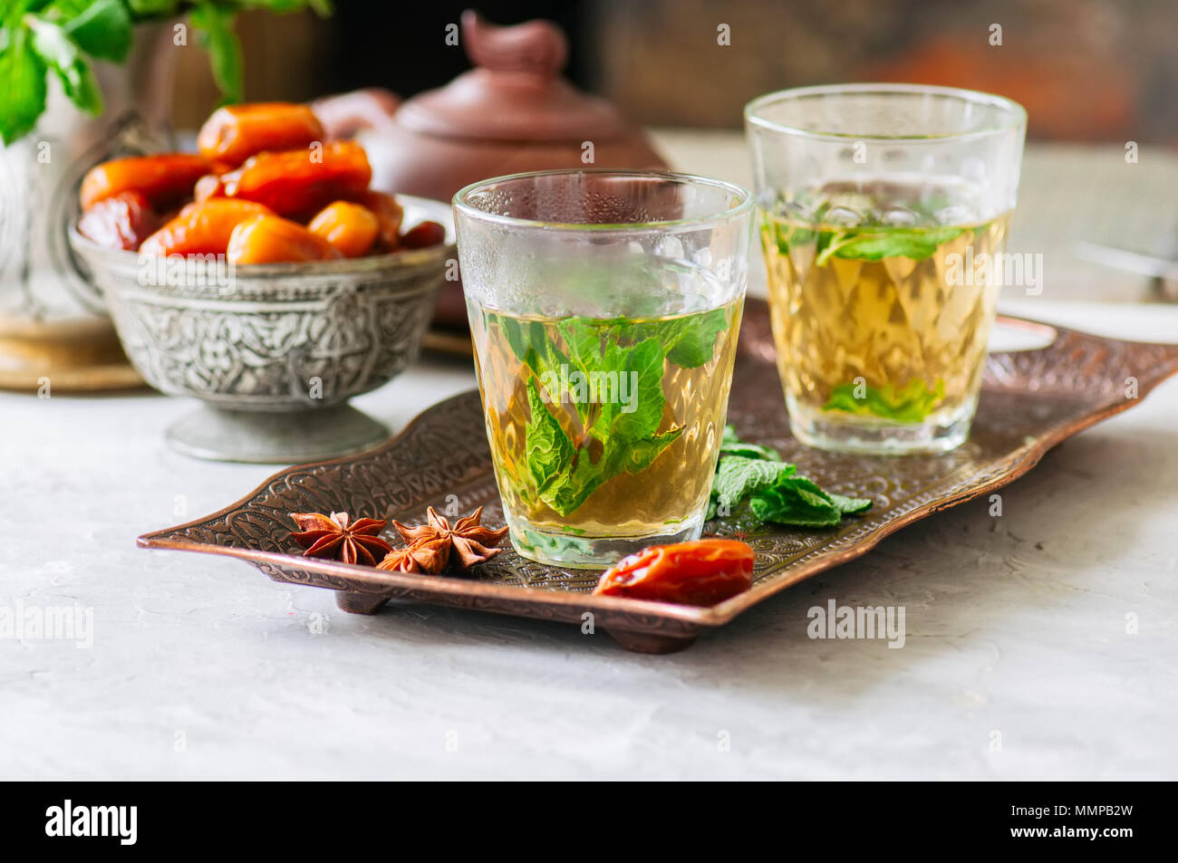 Marocchino tradizionale tè alla menta con date su un vassoio vintage Pietra Bianca dello sfondo. Foto Stock