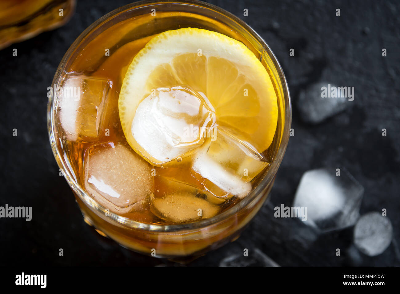 Whiskey una palla alta cocktail con limone e cubetti di ghiaccio su sfondo nero, copia dello spazio. Foto Stock